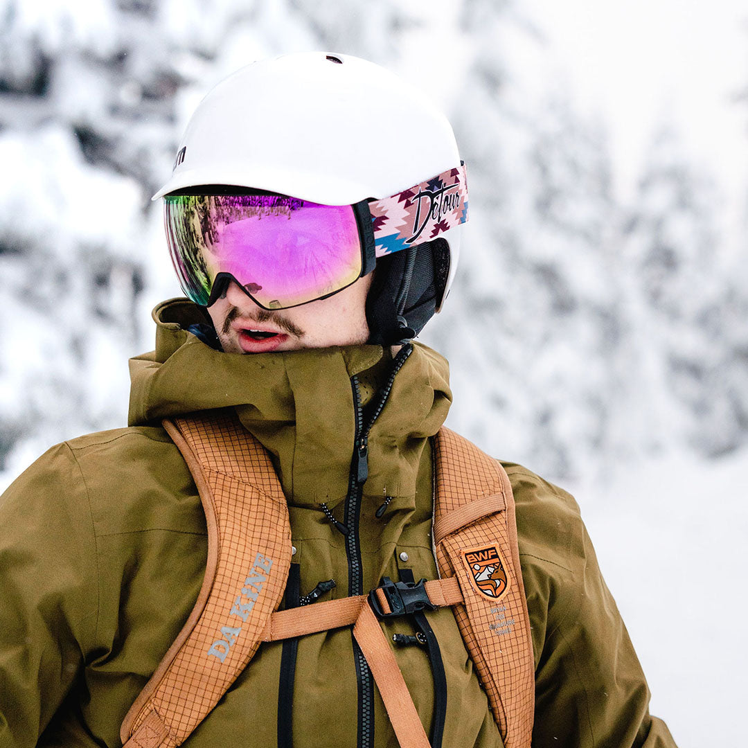 Person in winter gear and goggles on a snowy mountain.